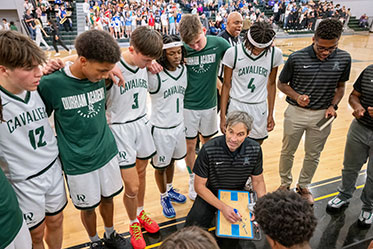 A coach going over the next play with his team. Links to Over Age 65 A coach going over the next play with his team. Links to Over Age 65